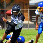 three people playing football in full uniforms and helmets