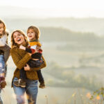 man and woman outdoors with two children