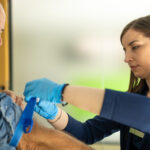 Female healthcare provider taking blood sample from man